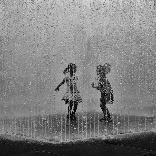 girls playing in a water fountain