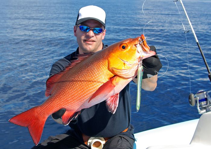 fisherman holding a big red snapper fish